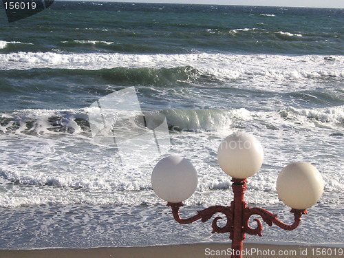 Image of globe street light infront of the ocean