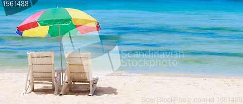 Image of Panorama of tropical beach with chairs and umbrella