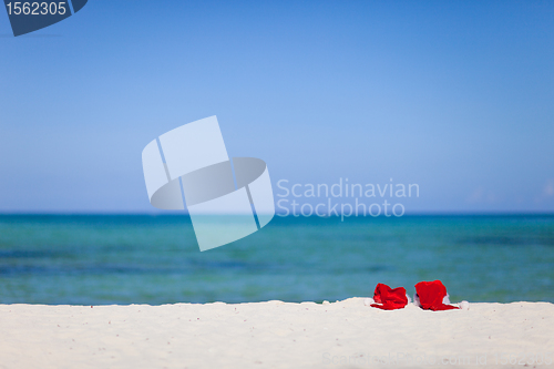 Image of Two santa hats on beach