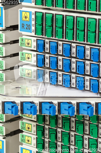 Image of fiber optic rack with high density of blue and green SC connectors