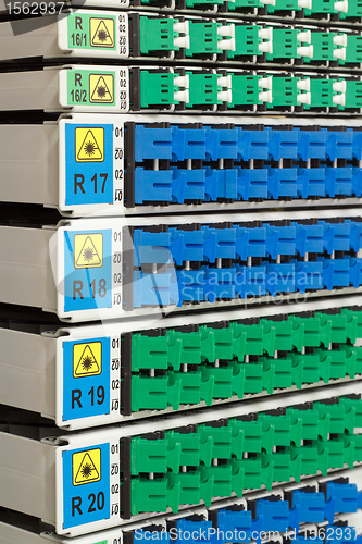 Image of fiber optic rack with high density of blue and green SC connectors