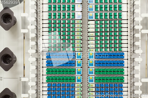 Image of fiber optic rack with high density of blue and green SC connectors