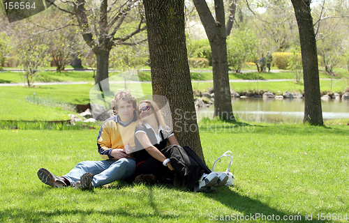 Image of Romantic couple sitting in a park.