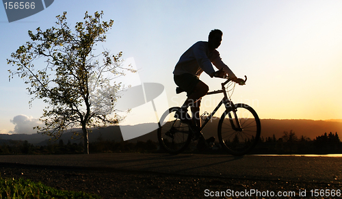 Image of Man riding his bike at sunset