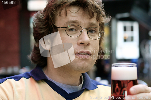 Image of Young man holding a glass of beer