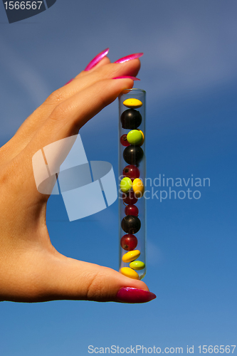 Image of test tube with tablets, berries and plant