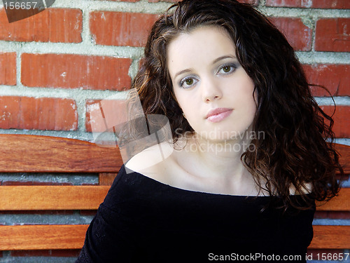 Image of Beautiful young woman against brick wall