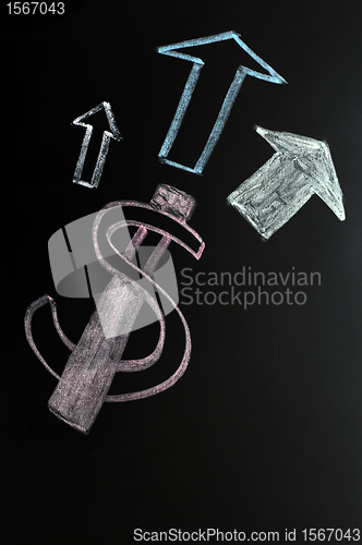 Image of US Dollar symbol with up arrows written on a blackboard