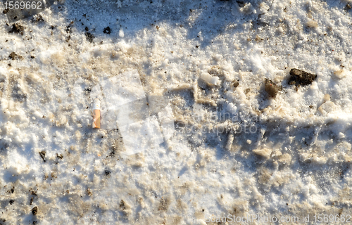 Image of Winter snow path closeuo background cigarette butt 