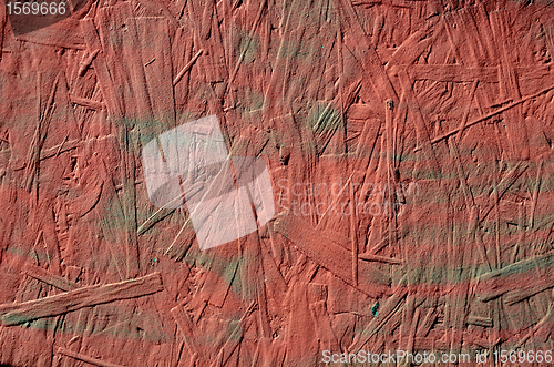 Image of grunge red painted chipboard closeup background 