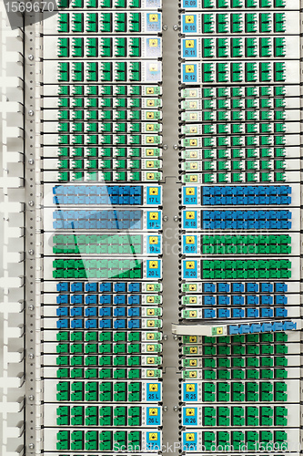 Image of fiber optic rack with high density of blue and green SC connectors