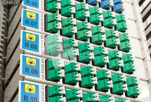 Image of fiber optic rack with high density of blue and green SC connectors