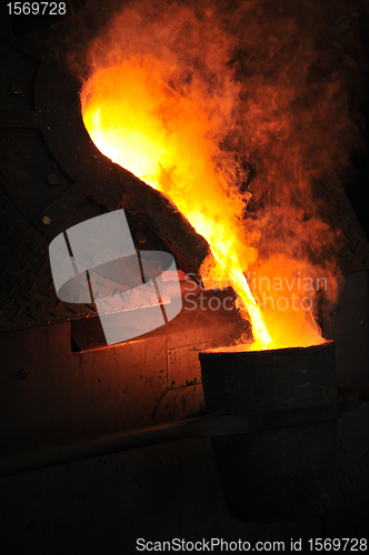 Image of Foundry - molten metal poured from ladle for casting