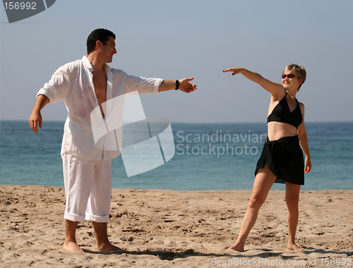 Image of Young couple dancing on the beach