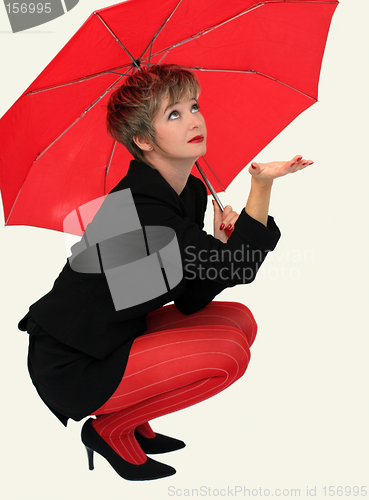 Image of Businesswoman with a red umbrella looking up