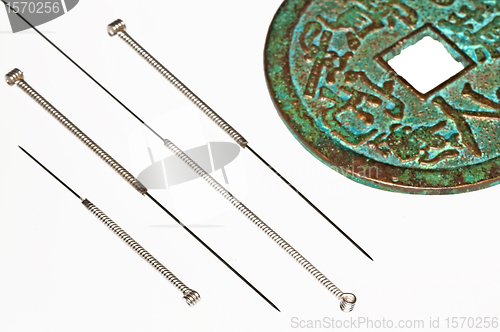 Image of acupuncture needles with chinese coin