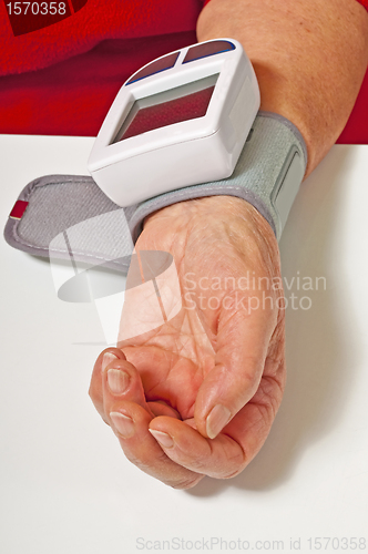 Image of pensioner is measuring her blood pressure