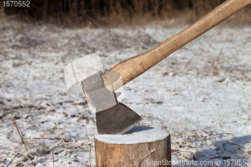 Image of Axe and log in winter forest