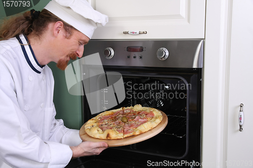 Image of Young chef prepared italian pizza in kitchen