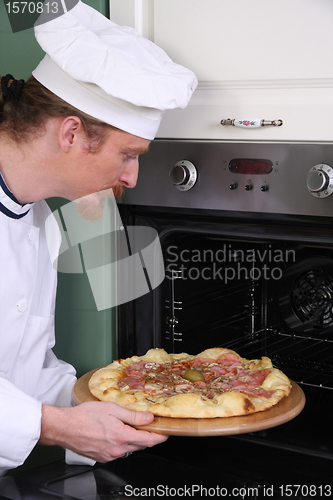 Image of Young chef prepared italian pizza in kitchen