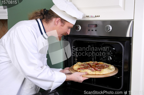Image of Young chef prepared italian pizza in kitchen 