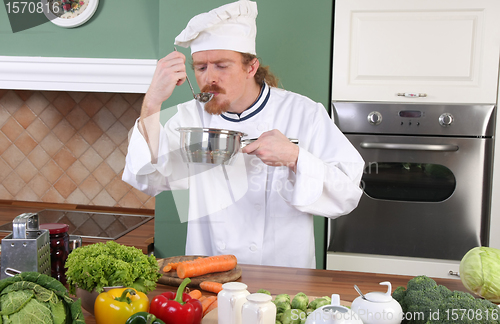 Image of young Chef tasting food with a tablespoon