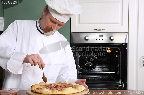 Image of Young chef prepared italian pizza in kitchen