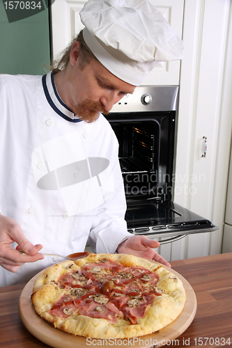 Image of Young chef prepared italian pizza in kitchen