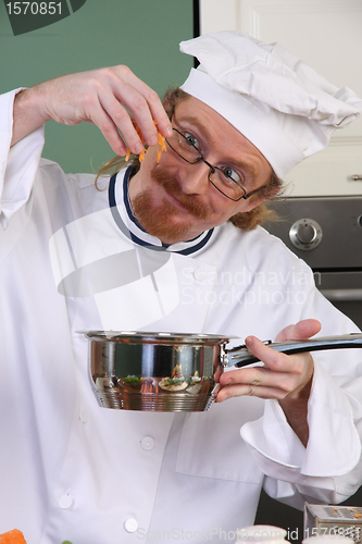 Image of Funny young chef add carrots in the pot