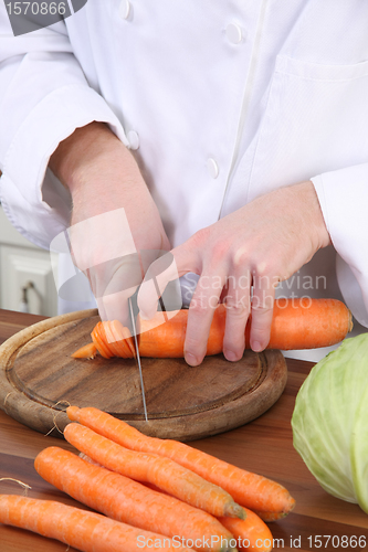 Image of Chef preparing lunch and cutting carrot with knife