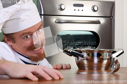 Image of Funny young chef with a pot