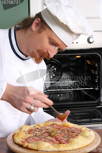 Image of Young chef prepared italian pizza in kitchen