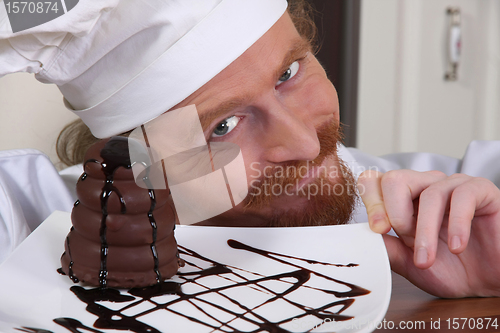 Image of Young chef with piece of cake