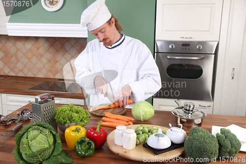 Image of Young chef preparing lunch in kitchen