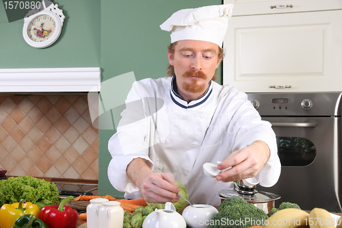 Image of Young chef preparing lunch in kitchen
