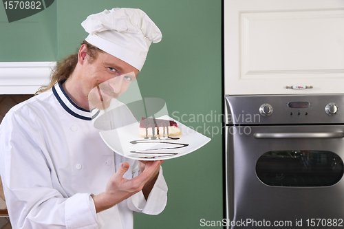 Image of Young chef with piece of cake