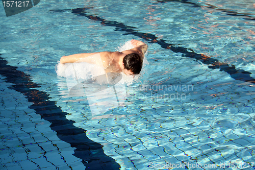 Image of Young athletic man working out swimming in pool