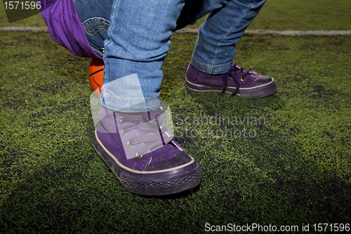 Image of Child sitting on a basketball