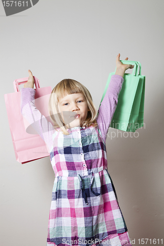 Image of Little girl with shopping bags and lollipop