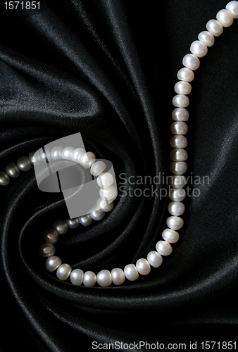 Image of White pearls on the black silk background