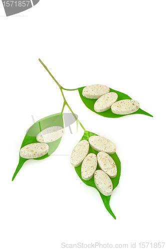 Image of Natural supplement pills and fresh leaves