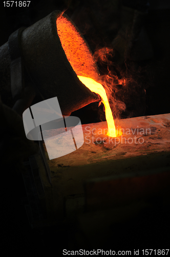 Image of Foundry - molten metal poured from ladle into mould