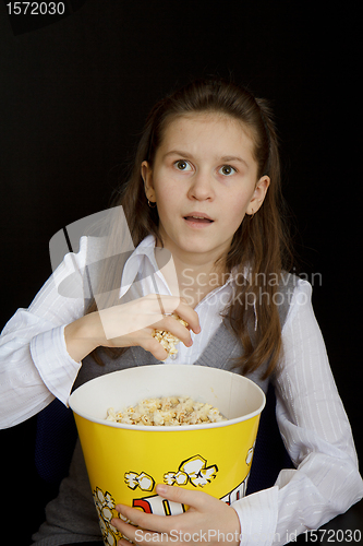 Image of surprised girl with popcorn on a black background