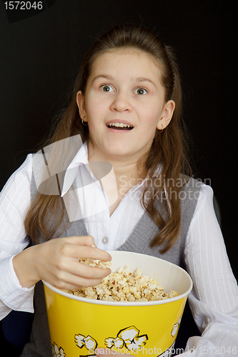 Image of surprised girl with popcorn on a black background