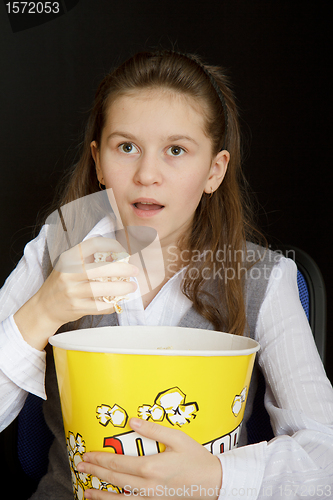 Image of surprised girl with popcorn on a black background