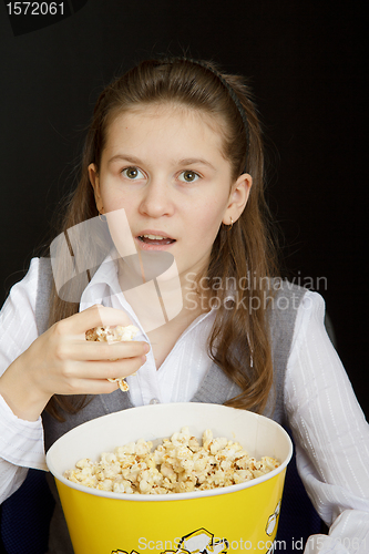 Image of surprised girl with popcorn on a black background