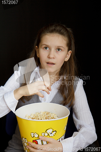 Image of surprised girl with popcorn on a black background