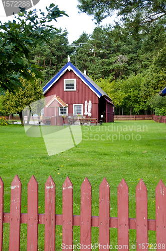 Image of Wooden colorful house well fence rural homestead 