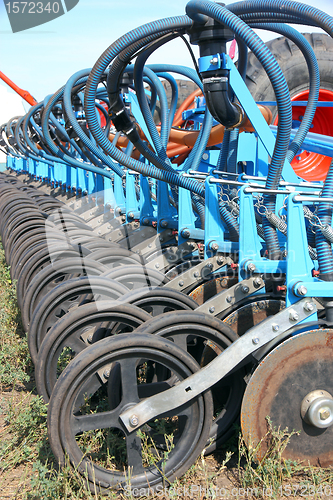 Image of tractor and seeder planting crops on a field