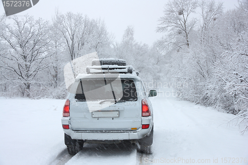 Image of Snowy winter road behind an unrecognizable car